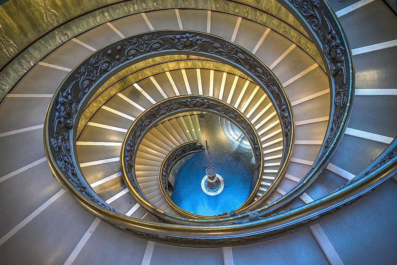 The double spiral staircase of the Vatican Museums designed by Giuseppe Momo, seen from below with its curving ironwork railing